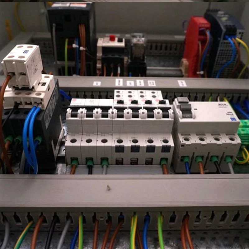 Inside a control panel: contactors and breakers on DIN rail with labelled wiring, from their gallery