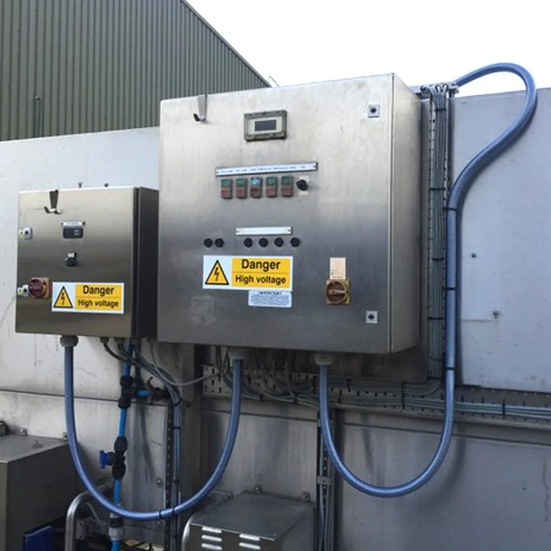 Two stainless steel control panels with isolators and conduit runs on an outside plant wall, from their gallery
