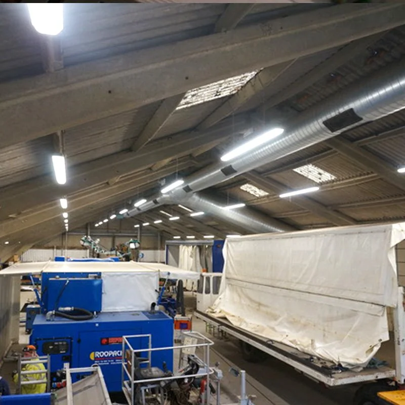 A large working shed lit by long rows of LED batten lights, with machinery and trailers on the floor, from White Electrical's gallery of recent projects